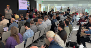 Photo of a crowd listening to Ernest Koe give a session on AI at the Claris Engage 2024 Speaker Sessions